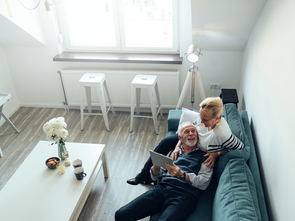 Pareja adulta que disfruta del confort de su hogar sentados en el sillón de su salón